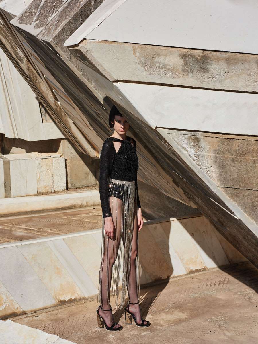 Body από παγιέτες και
ζώνη με κρύσταλλα,
όλα Mi-Ro, MI-RO
Boutique. Πέδιλα
από λουστρίνι
με μεταλλικές
λεπτομέρειες Philipp
Plein, Philipp Plein
Boutique.