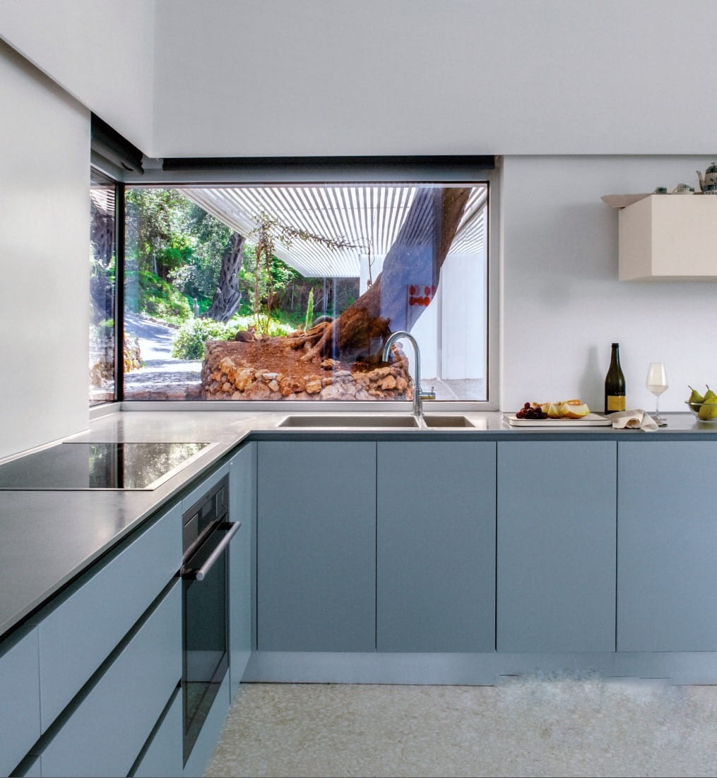 Η κουζίνα με λιτή σύνθεση από γκρι λάκα και corian πάγκο εργασίας