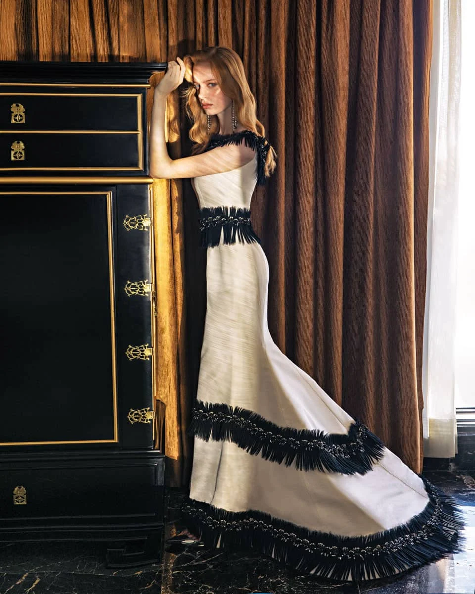 Off the shoulder φόρεμα από ύφασμα Mikado με λεπτομέρειες από κεντημένο τούλι με βολάν, Vassilis Emmanuel Zoulias. Σκουλαρίκια, Pericles Kondylatos. Δερμάτινα slingbacks, Alexandre Vauthier, Kalogirou.