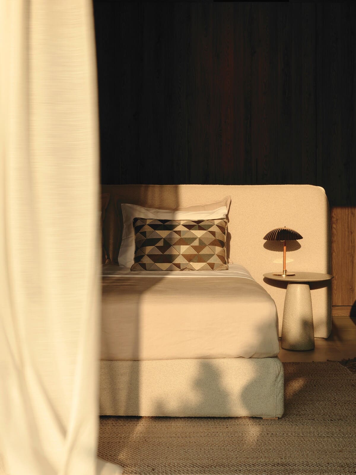 Στο master bedroom, τοίχοι επενδεδυμένοι με γιούτα, χτιστό κρεβάτι με χαμηλή πλάτη (Karageorgiou Interiors) και φωτιστικά Gubi (Love-it).