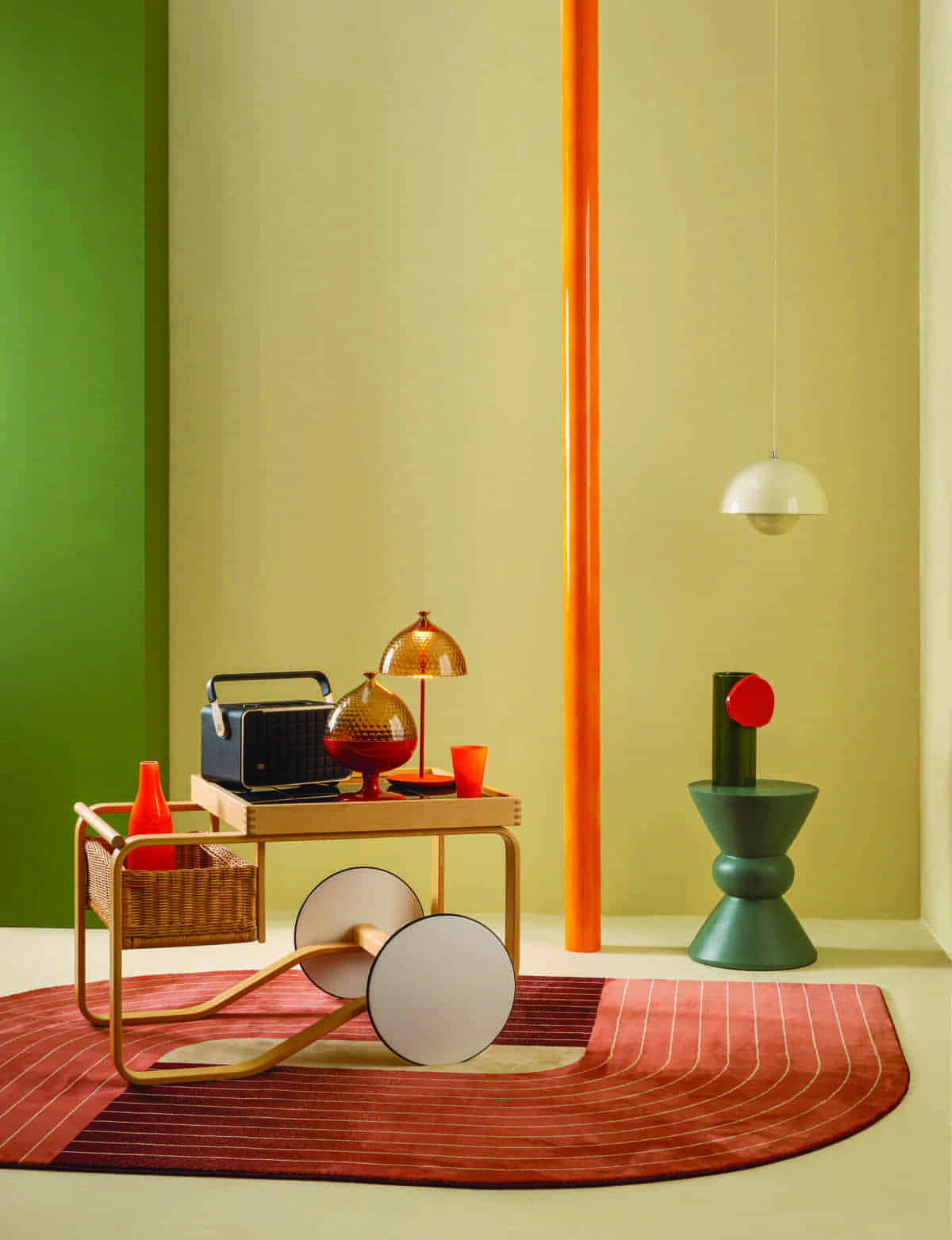 Τρόλεϊ “Tea Trolley 900”, σε σχέδιο του Alvar Aalto, της εταιρείας Artek, El Greco Gallery. Πορτοκαλί γυάλινη καράφα και ποτήρι της εταιρείας Fluid, 190 €, και 85 €, Deros The Shop. Ηχείο, bluetooth, wireless home speaker “Authentics 300”, της εταιρείας JBL, 479 €, WaveMotion. Βάζο αποθήκευσης και επιτραπέζια λάμπα, όλα “Pumo”, του Fabio Novembre για την εταιρεία Kartell, 140 € και 258 €, Kartell Area Domus. Γεωμετρικό χαλί “Chroma”, σε διάσταση 160x230 εκ., της εταιρείας Osta, Ιnspire. Πράσινο σκαμπό “Ives”, 175 €, Milano De. Πήλινο βάζο “Decoupage”, των Ronan & Erwan Bouroullec για την εταιρεία Vitra, El Greco Gallery. Φωτιστικό οροφής “Gallis Round E27 Champagne”, 49,90 €, Praktiker. Στον τοίχο εφαρμόστηκε πράσινο πλαστικό χρώμα Super Neopal 18GY 18/160, κίτρινο ζεστό 45YY 83/125 και πορτοκαλί 96YR 46/632, της εταιρείας Vivechrom, Σακαλόπουλος.