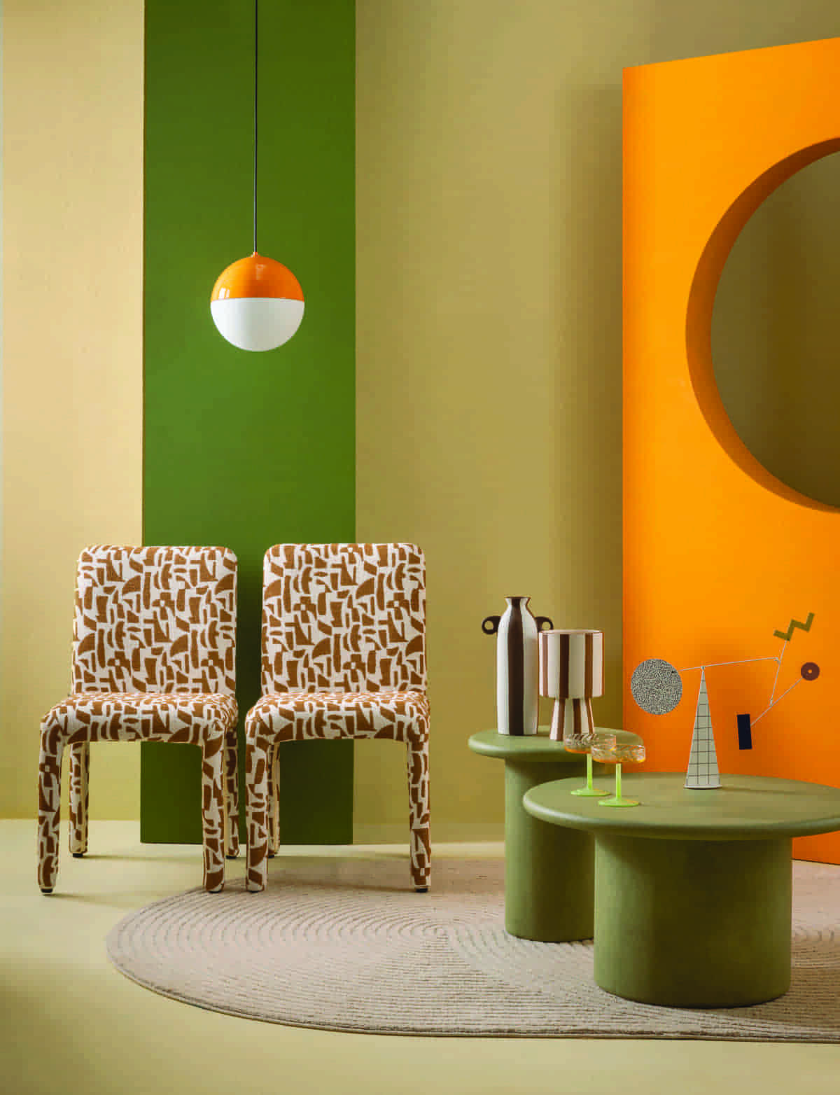 Καρέκλες “Waco Dining Chair” της εταιρείας Lifestyle, Interni. Φωτιστικό οροφής “Blast”, 120 €, Μοdernon. Ριγέ κεραμικό βάζο “Harmony & Living Earth”, 16,90 €, και κασπό “Boltze Nyuna”, 26,50 €, Praktiker. Ποτήρια σαμπάνιας “Coupe Twirl”, σετ 2 τμχ., της εταιρείας &Klevering, Oikos. Κινητικό γλυπτό “Sydney”, 150 €, Zoumboulakis Galleries. Τραπεζάκια σαλονιού “Solace” από τσιμεντοκονία, 380 € και 605 €, Milano De. Χαλί “Flux”, σε διάσταση 160x230 εκ., της εταιρείας Osta, Inspire. Στον τοίχο και το πάτωμα εφαρμόστηκε πράσινο πλαστικό χρώμα Super Neopal 18GY 18/160, κίτρινο ζεστό 45YY 83/125 και πορτοκαλί 96YR 46/632,της εταιρείας Vivechrom, Σακαλόπουλος.