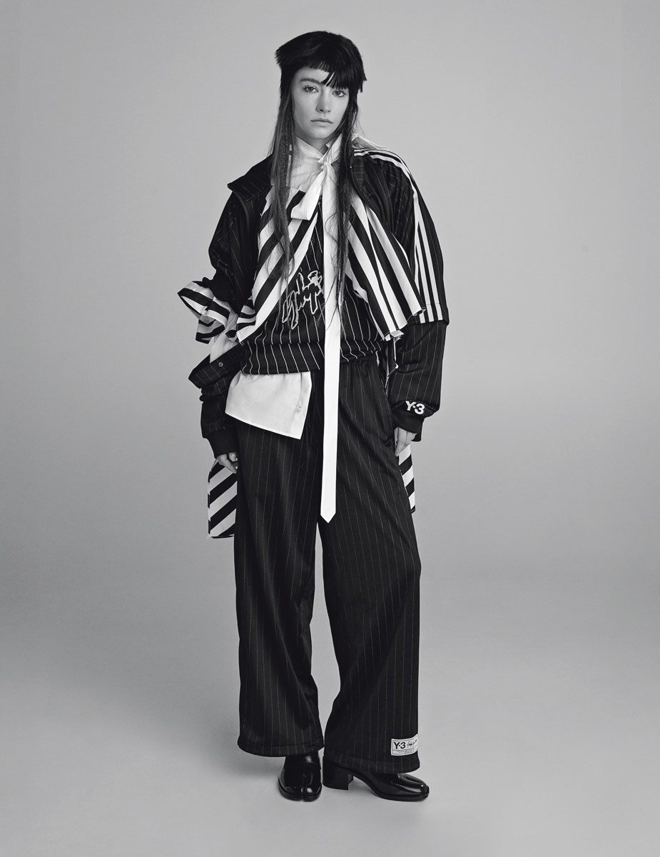 Μπουφάν, παντελόνι και φανέλα μπάσκετ adidas Y-3, Adidas Stores. Oversized βαμβακερό πουκάμισο με φιόγκο, Kenzo. Oversized βαμβακερή ριγέ τουνίκ φορεμένη ανάποδα Jacquemus, Free Shop. Δερμάτινα mules Maison Margiela, Kalogirou.
