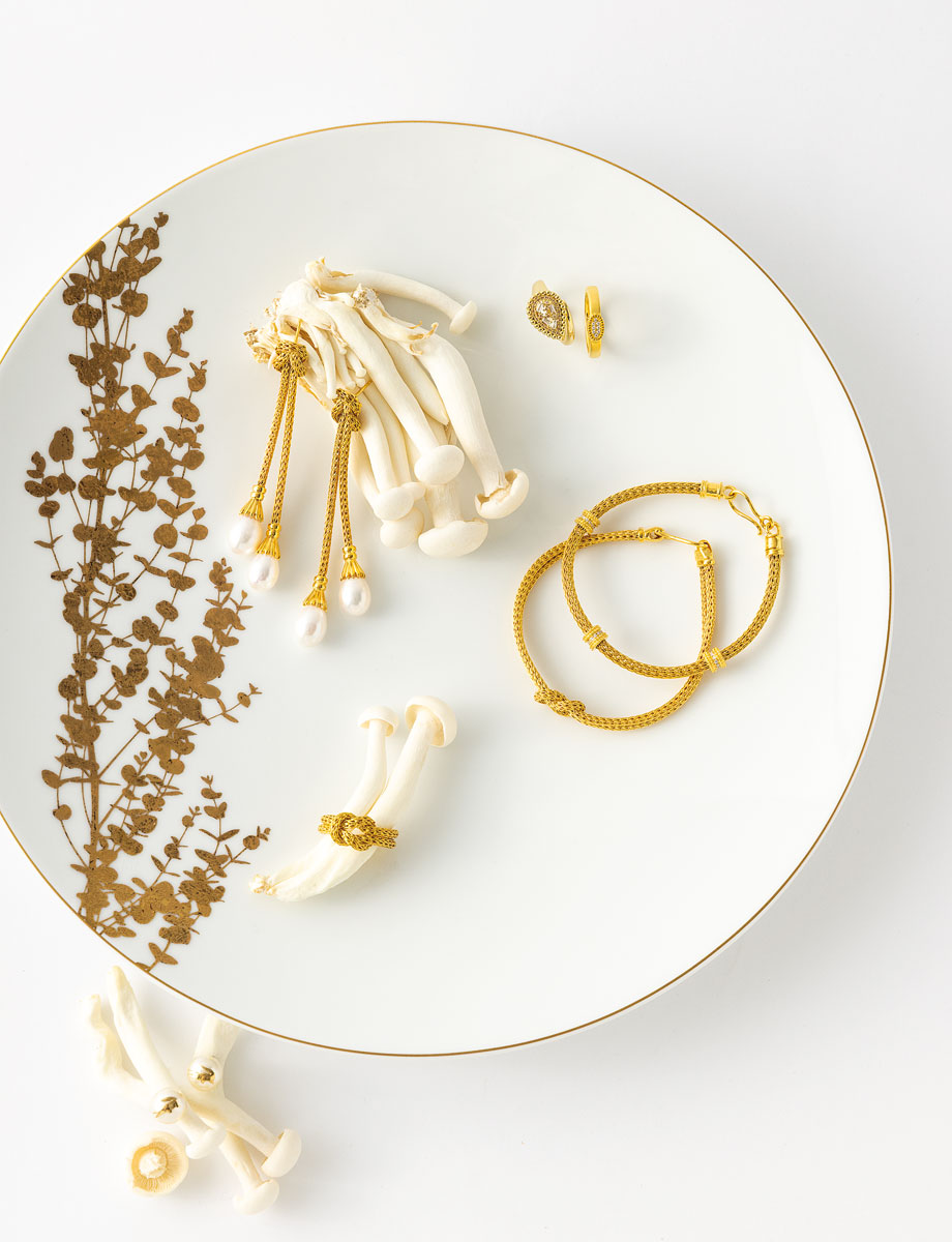 Σκουλαρίκια Snake Lace από χρυσό 18K με μαργαριτάρια, Βραχιόλι Snake Lace από κίτρινο χρυσό 18K με διαμάντια, βραχιόλι Snake Lace από κίτρινο χρυσό 18Κ και δαχτυλίδι Snake Lace από κίτρινο χρυσό 18k, όλα Zolotas. Δαχτυλίδια από επιχρυσωμένο ασήμι 925 και λευκά ζιργκόν, Jools Atelier. Επιχρυσωμένα Σκουλαρίκια από ατσάλι με πέρλες, Lacoste, Chronoteam. Πορσελάνινο πιάτο φαγητού λευκό με χρυσό, από τη συλλογή VEGETAL OR, της εταιρείας Bernardaud, 197 €, Christhellas.
